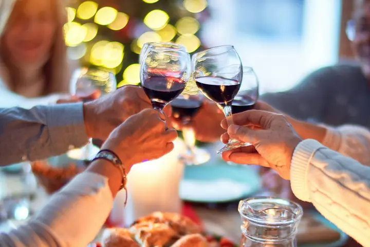 Friends raising their glasses over a dinner table